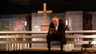 Steffen Reiche auf Chorpodest mit Kreuz und Kulisse mit gyptischen Malereien im Hintergrund