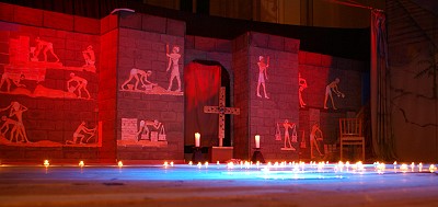 rotblau ausgeleuchteter Bhne mit Kreuz, Kulissen mit gyptischer Malerei im Hintergrund